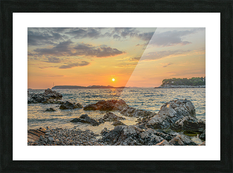 Sunset over rocky beach Picture Frame print
