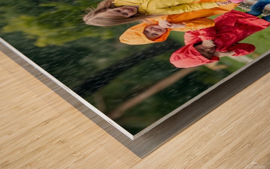 A Group of Children Playing in the Rain Jumping in Puddles Wood print