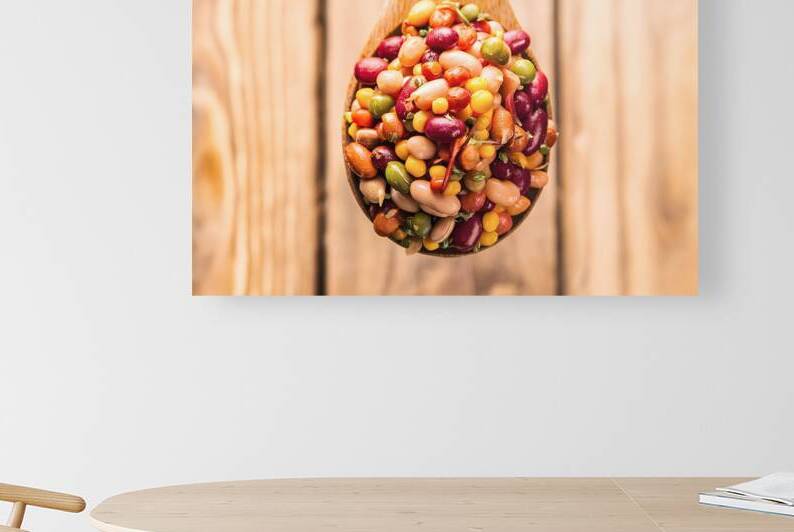 A wooden spoon filled with a vibrant mix of pulse by Romeu Hurmuzache