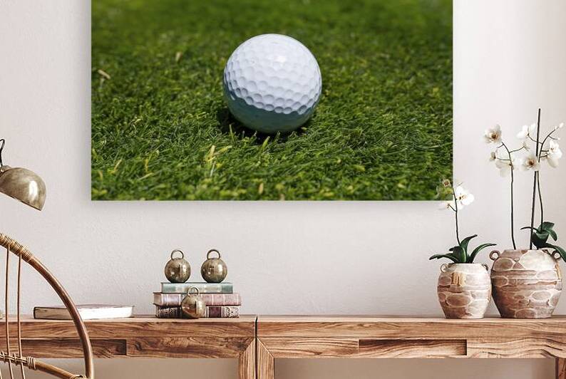 A close up view of a golf ball placed on a lush g by Romeu Hurmuzache