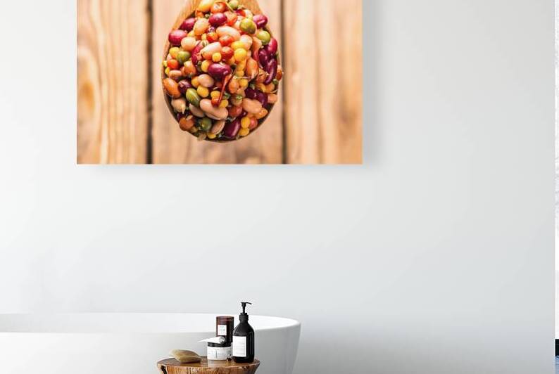 A wooden spoon filled with a vibrant mix of pulse by Romeu Hurmuzache