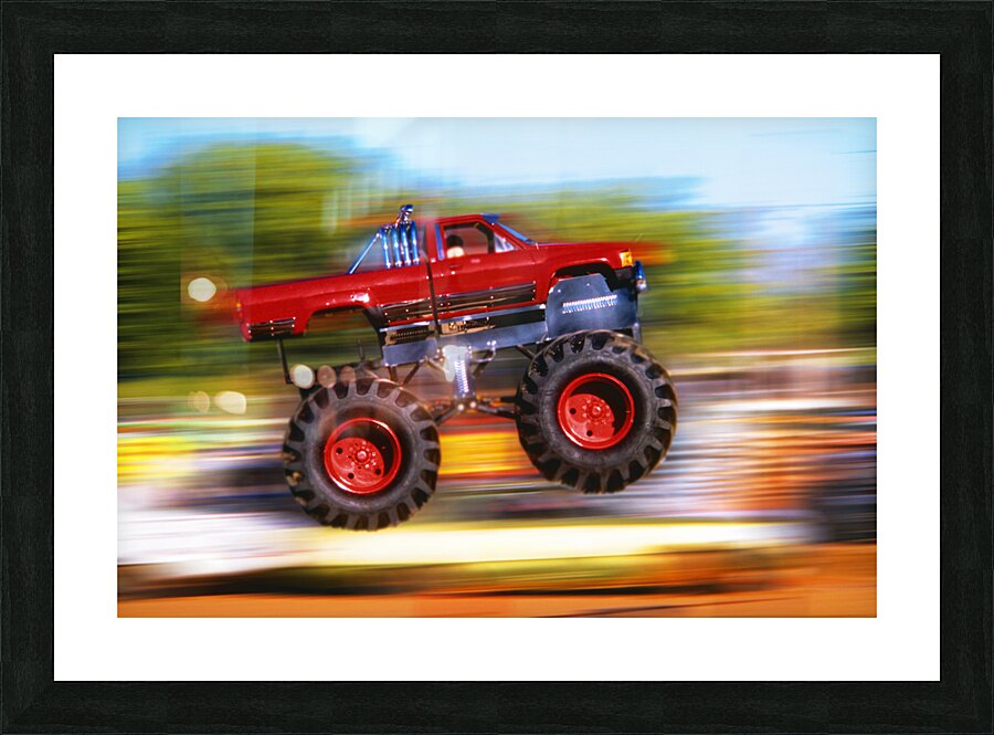 BIG WHEELED RED TRUCK JUMPING BLURRED BACKGROUND 184837 Picture Frame print