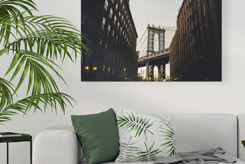 View of the Manhattan Bridge in between two New York City apartment buildings.  by Jon dev 