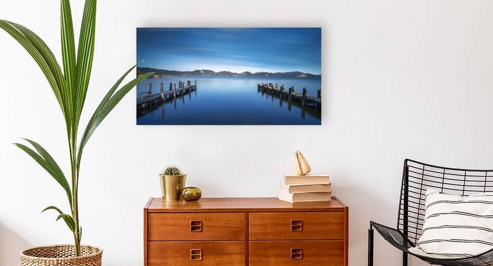 Two Wooden pier or jetty and on a blue lake sunset and sky refle by Stefano Orazzini