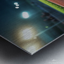 View of a well lit athletic track at night showcasing vibrant red surface and brightly illuminated surroundings Metal print