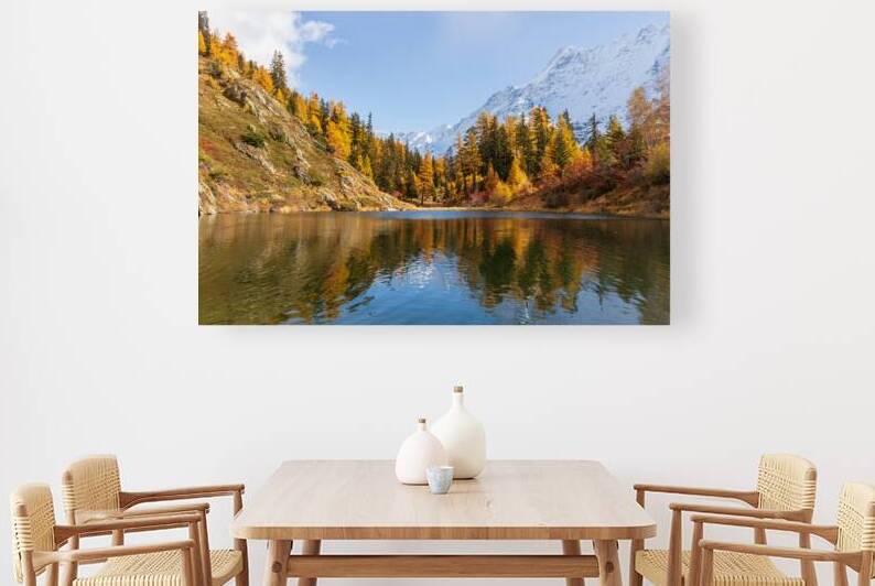 Autumn larch forest and snow covered mountains reflected in swiss alpine lake. by Ad Gr