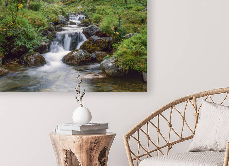 A serene waterfall cascades through a lush green forest offering tranquility. by IB Photography