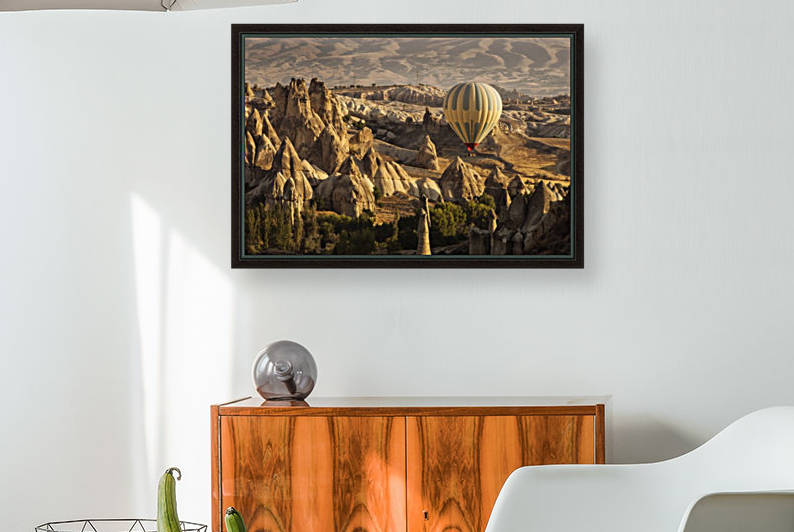 Hot air balloon flying over rock landscape at Cappadocia Turkey by MIRICA DAN-ALEXANDRU