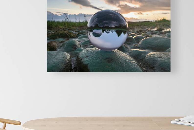 claer glass ball lens lies on stones covered with by Liviu Ghitun
