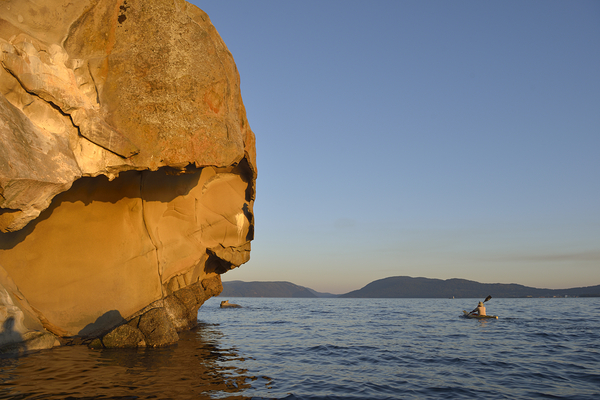 Sea kayaking under sculpted sandstone cliffs Digital Download