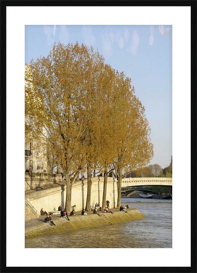 Enjoying a warm spring day on the banks of the Seine River - Paris Picture Frame print