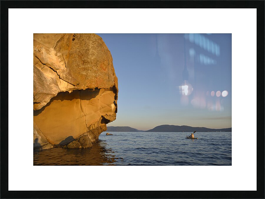 Sea kayaking under sculpted sandstone cliffs Picture Frame print