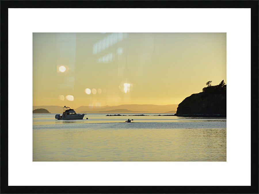 Kayaker and motor boat at anchor in Fox Cove. Sucia Island Picture Frame print