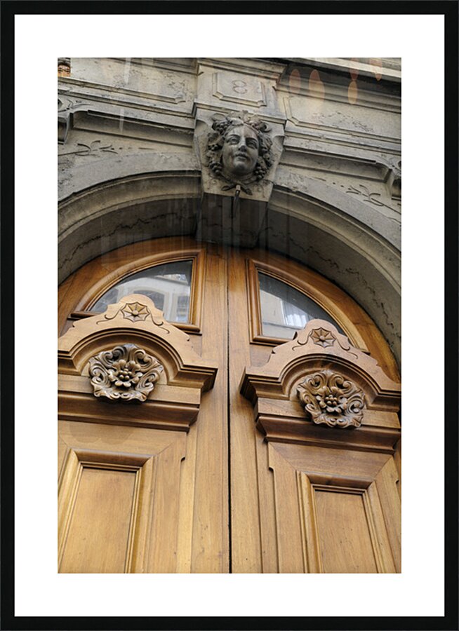 Wooden door with carved figurine in stone above it. France Picture Frame print