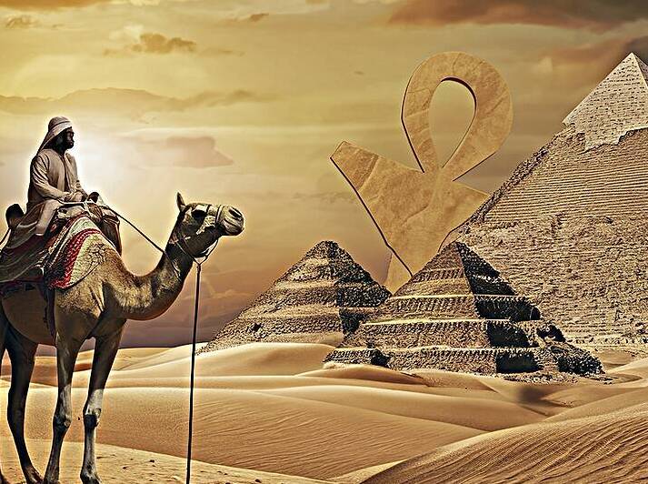 Bedouin on camel near pyramids and ankh in desert by Lupu Andrei