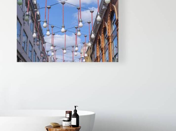 Light bulbs hanging across the buildings for Christmas decorations London by Assaf Frank