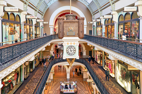 Elegant Victorian shopping arcade with clock tower and shoppers. Digital Download