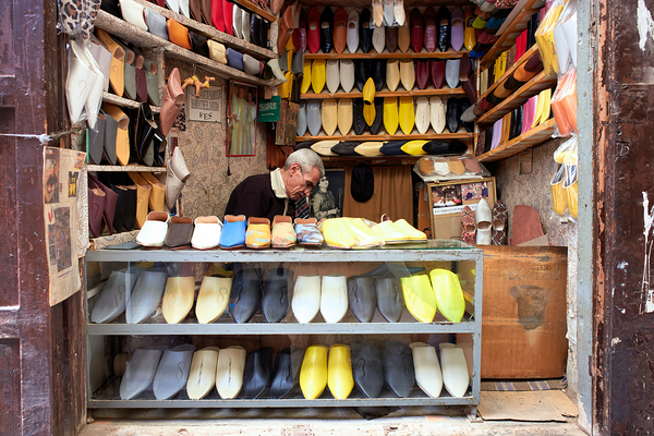 Moroccan babouches shoes in a Fez shop with a vendor Digital Download