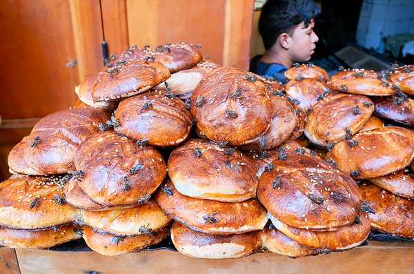 Loaf of bread covered in flies at market in Fez Morocco Digital Download