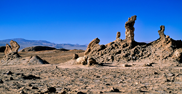 Arid desert with unusual rock pillars against a blue sky. Digital Download