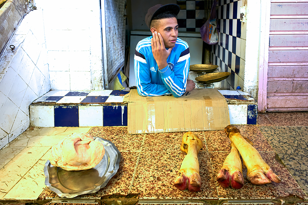 Butcher in Meknes souk interacts with customers during market ho Digital Download