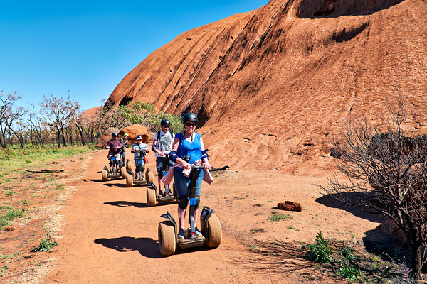 Tourists ride Segways near Uluru in Australia. Digital Download