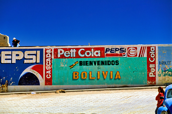 Welcome to Bolivia sign on a wall with old ads. Digital Download