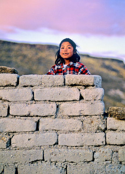 Young girl smiles over stone wall at sunset. Digital Download