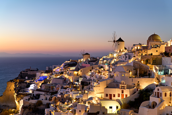 Santorinis Oia village glows at twilight by the sea. Digital Download
