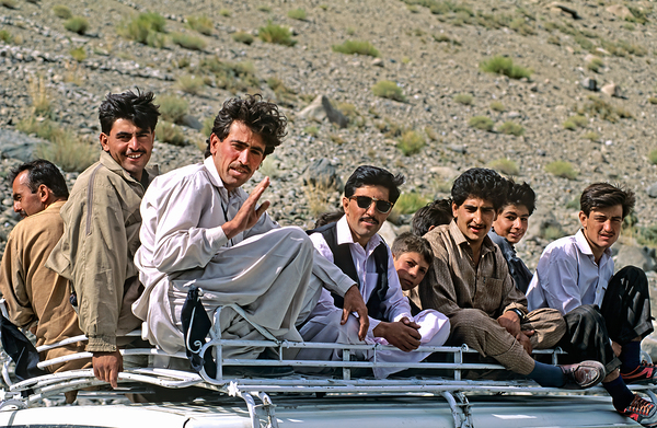 Group traveling on top of a van in Pakistans mountains Digital Download