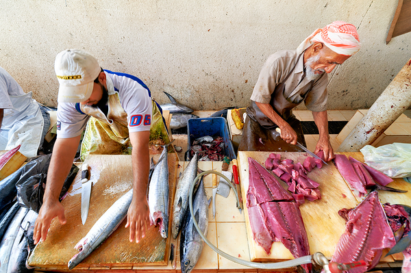 Fish market in Muscat Oman shows workers preparing fish Digital Download