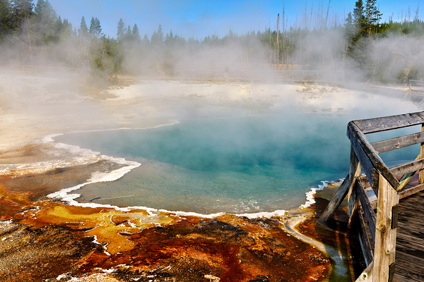 Steam rises from Abyss Pool as blue water reflects the surrounding landscape at Yellowstone National Park. Visitors explore the area nearby. Digital Download
