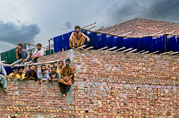 Workers rest during break time at a construction site in Lahore Digital Download