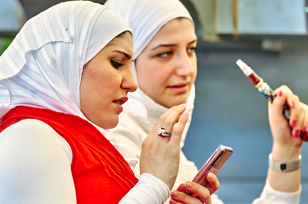 Young women enjoy hookah and talk on mobile phone in Aleppo Syri Digital Download