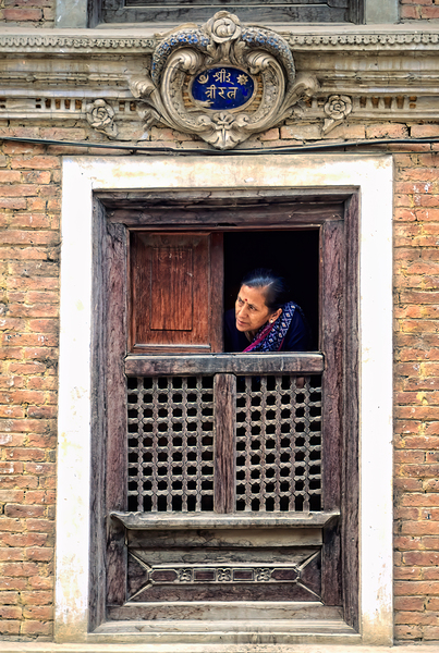 Woman in Kathmandu looks out from window in old building Digital Download