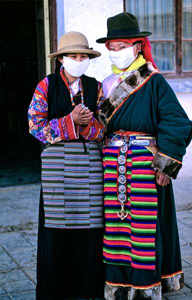 Masked individuals in traditional clothing hold hands in Tibet Digital Download