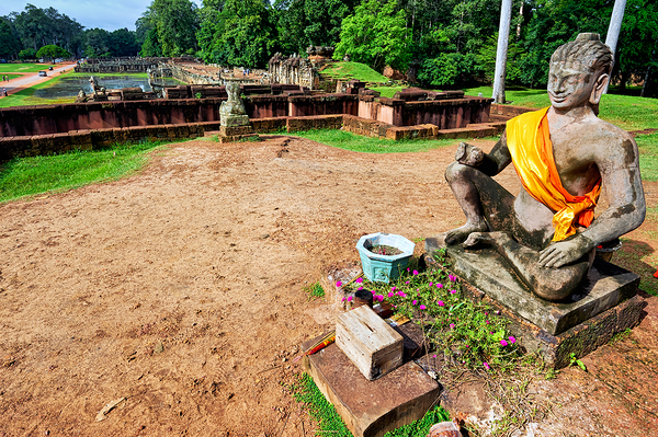 Ancient statue overlooks temple ruins amidst lush greenery. Digital Download