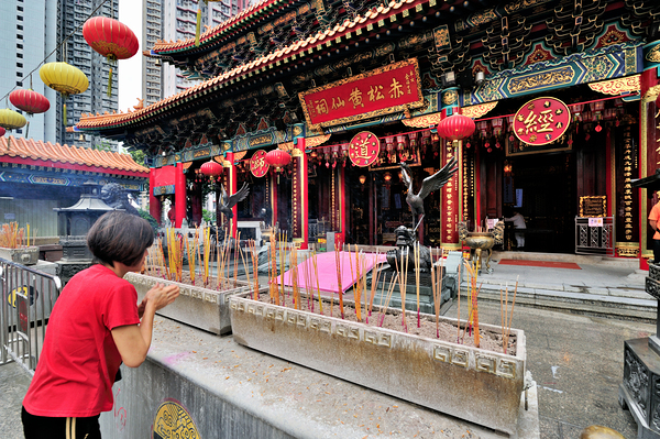 Woman prays with incense at colorful Chinese temple in Hong Kong Digital Download