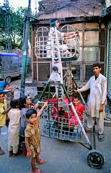 Children enjoy playtime on a swing in Lahore Digital Download