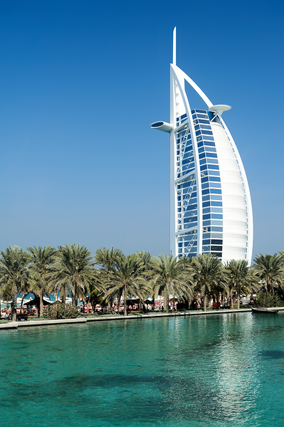 Burj Al Arab hotel stands tall by the water with palm trees Digital Download