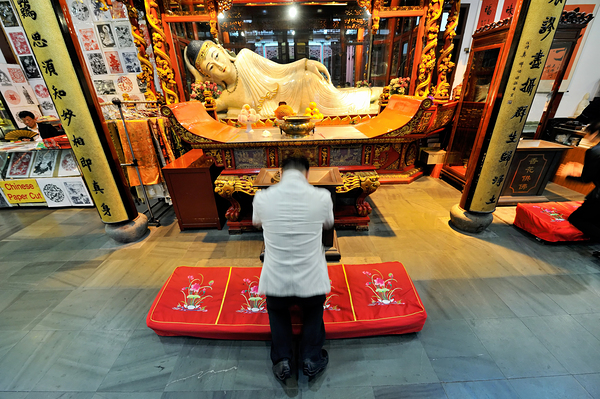 Worshipper kneels before Buddha statue in Shanghai temple Digital Download
