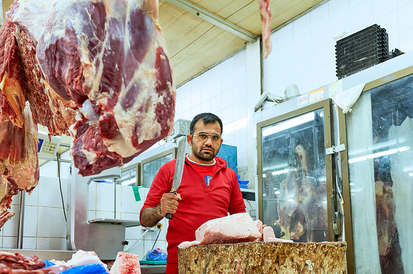 Butcher works with meat in a shop in Dubai UAE Digital Download