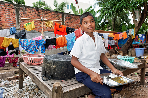 Boy with food tray clothes drying in background. Digital Download