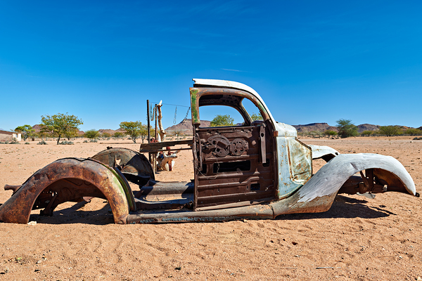 Classic car wreck rests in the Namib desert under a clear sky Digital Download