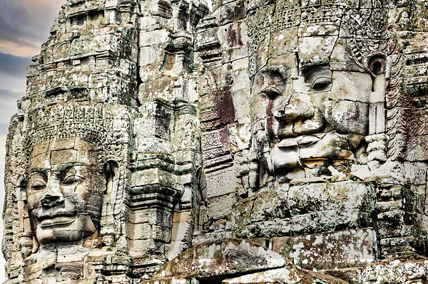 Serene stone faces adorn ancient Cambodian temple. Téléchargement Numérique