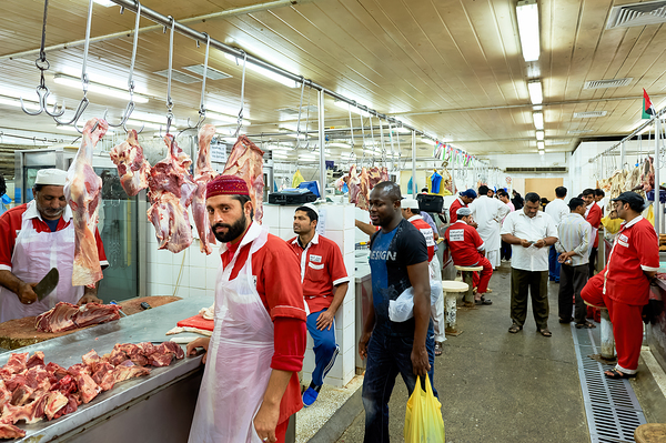 Butchers work at a busy meat market in Dubai UAE preparing fresh Digital Download
