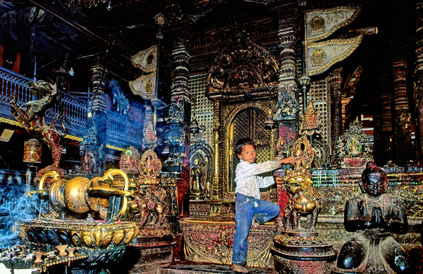 Boy interacts with religious artifacts in Kathmandu temple Digital Download