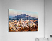 Santorini cliffside town at sunset with mountain backdrop. Acrylic Print