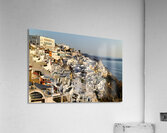 Santorinis white buildings cascade down cliff to the sea. Acrylic Print