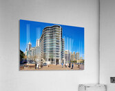 Modern curved building with balconies and city skyline. Acrylic Print
